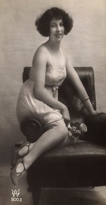 En ung kvinde poserer i sin underkjole, siddende i en lænestol af Unknown photographer