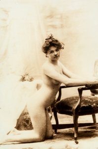 Nøgenportræt af en ung kvinde, der knæler foran en lille lænestol. af Unknown photographer