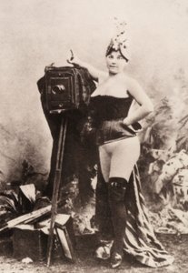 Portræt af en delvist nøgen kvinde, der læner sig op ad et antikt kamera. af Unknown photographer