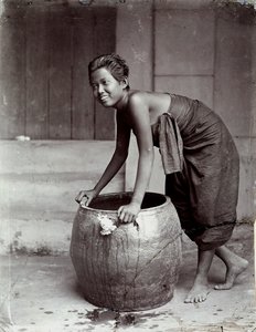 Ung smilende thailandsk kvinde skubber en stor container af Unknown photographer