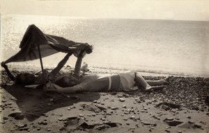 To kvinder ligger på stranden i skyggen af et håndklæde. Postkort sendt af fotografen til Vincenzo Balocchi af Vincenzo Balocchi