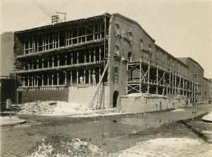 Byggeplads, to mænd stående i åben side af lagerbygning; Robbins und Ripley Engineers and Contractors, 23. marts 1916 af William Davis Hassler