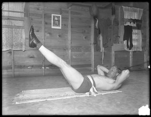 Den engelske bokser William Thomas Wells (Bombardier Billy Wells), poserer i træningsbukser, der laver benløft, ca. 1911