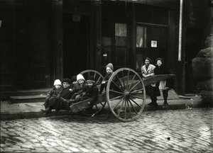Gruppe af børn i vogn, med pige og kvinde bagved, ca. 1910-21 af William Davis Hassler