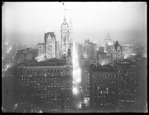 Højvinklet, tåget natudsigt over nedre Manhattan, der ser mod nord, med Singer Building, Woolworth Building og Municipal Building synlig, ca. 1913 af William Davis Hassler