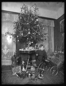 Seymour-dreng med trehjulet cykel ved siden af juletræet i stuen, jul 1912