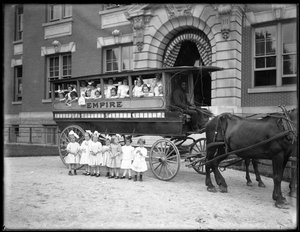 Små piger poserer i og foran en hestevogn foran en uidentificeret bygning, sandsynligvis det romersk-katolske forældreløse asyl, Kingsbridge, Bronx, ca. 1910 af William Davis Hassler