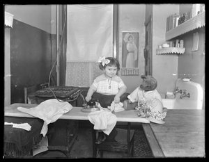 Uidentificeret lille pige demonstrerer brugen af et elektrisk strygejern, ca. 1913-14 af William Davis Hassler