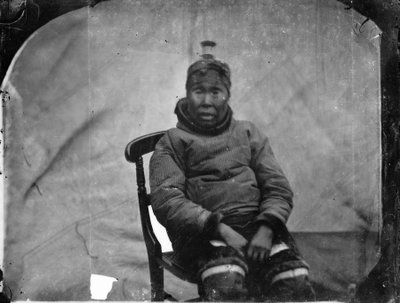En ældre inuk-kvinde sidder i en stol af Admiral Edward Augustus Inglefield
