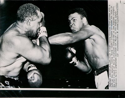 Unge Cassius Clay scorer med venstre mod veteranen Archie Moore i første runde af kampen i Los Angeles af American Photographer