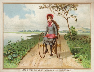 Pige kører på en trehjulet cykel på landet af American School