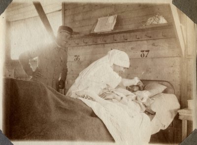 Første Verdenskrig 1914-1918: Sygeplejerske i bluse barberer en soldat (franske krigsskader ligger i en seng) i Couville, Manche, Basse-Normandiet (Basse-Normandiet), Frankrig. Anonymt fotografi juli 1917. Privatsamling, Stella. af Anonymous Anonymous