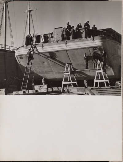 [En gruppe mænd arbejder på en båd i havn]. af Arnold Eagle