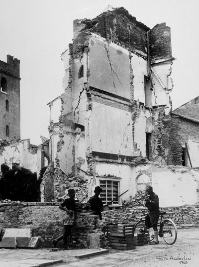 Bombardementerne af Sermide. Tre personer foran en gruppe bombarderede huse af Baccarini and Porta