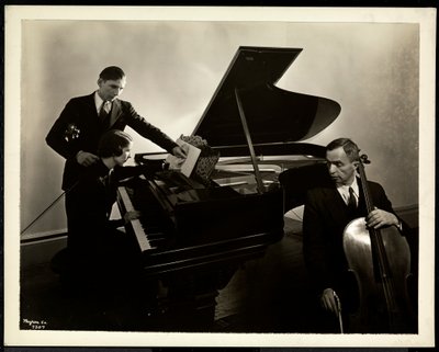 Blind kvinde, Miss Harding, ved klaveret instruerer to blinde mænd i violin og cello, 1936 (sølv gelatinetryk) af Byron Company