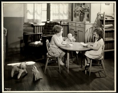 To blinde synshandicappede piger spiser ved et lille bord med en dukke hos New York Association for the Blind, 111 East 59th Street, New York, 1933 (sølv gelatinetryk) af Byron Company