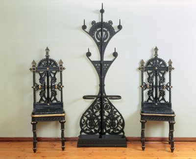 Frakke-, hat- og paraplystativ flankeret af to have- eller hallstole, Coalbrookdale, 1867-69 (støbejern) af Christopher Dresser
