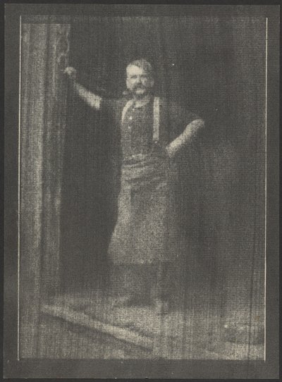[Smeden står i døråbningen med en pibe i munden]. af Doris Ulmann