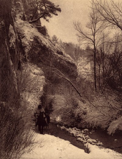 Passerer klippen, vinterscene. Apsaroke-indianere rider langs en klippe i sneen ved Pryor-floden, Montana. Foto taget fra bind 4 af encyklopædien udgivet af Edward S. Curtis (1868-1952) om indianerne i Nordamerika, med et forord af Theo af Edward Sheriff Curtis