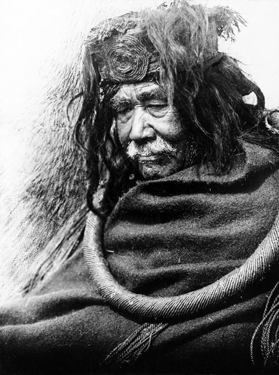 Hamatsa, Nakoaktok ca. 1910 Halv-længde portræt af Nakoaktok mand, vendt mod venstre, iført ceremoniel løkke af cedertræ. af Edward Sheriff Curtis