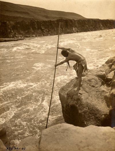 Tlakluit-indianer, stående på klippe, fisker med dykkernet, ca. 1910 (s/h-foto) af Edward Sheriff Curtis