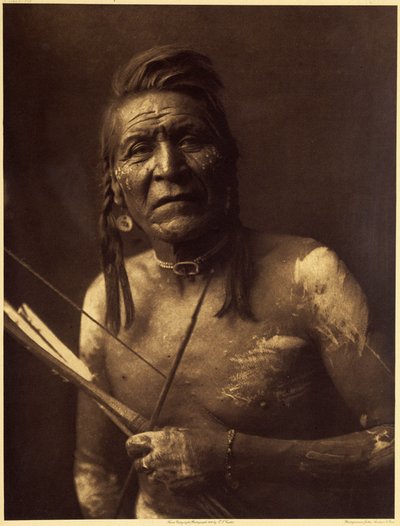 Two Leggings, Apsaroke, gjorde omkring 1848. Hans visioner gav ham ikke store kræfter, og han blev optaget i et hemmeligt tobaksselskab af Bull Goes Hunting, som gav ham sin amulet lavet af et fossil eller en groft sulptee sten i form af en tosidet hest. af Edward Sheriff Curtis