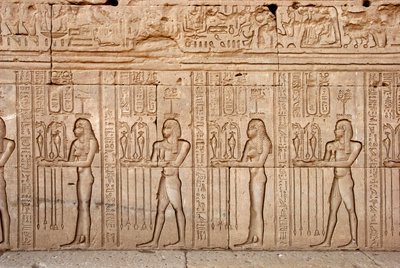 Egyptisk antikvitet: ofringer og hyldest til gudinden, Hathor-templet, Denderah, Egypten - Egyptisk civilisation: ofringer og hyldest til gudinden - figurer udskåret på væggen af Hathor-templet (eller Tentyra-templet) i Denderah, af Egyptian Ptolemaic Period