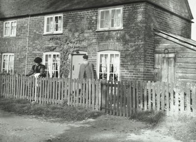 En landlig scene i Wandsworth-området med et ældre ægtepar i haven til en ejendom i hyttestil, London, 1895 af English Photographer
