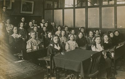 Piger sidder i et klasseværelse af English Photographer