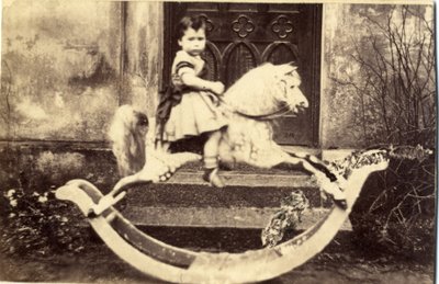 Lille pige på en stor gyngehest i en have, 1860