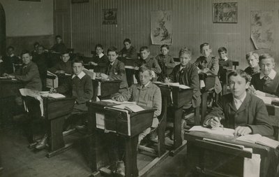 Mandlige elever, der sidder bag deres skriveborde under en lektion i skolen af English Photographer
