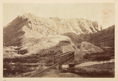 Udsigt på Pacific Railway, af jernbanespor, der krydser en flod på en bjælkebro, med bjerge bagved af English Photographer