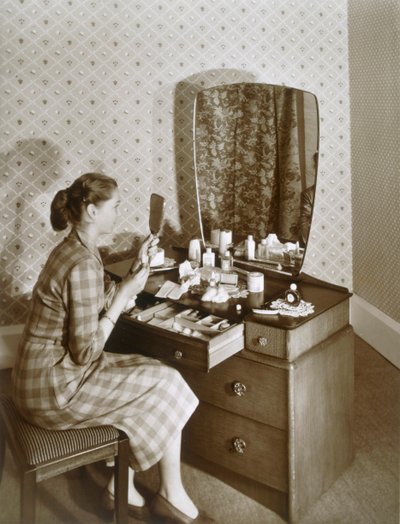 Kvinde ved hendes toiletbord, c1955. af English Photographer