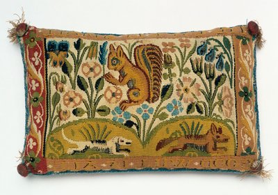 Et tapestry-panel med nålepude med et egern og motto "god vilje er alt" af English School