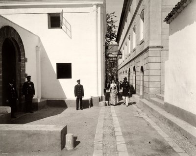 Mænd i uniform, der ledsager en elegant klædt kvinde mod kirken på gården Lo Zucco, Sicilien, 1900 af Eugenio Interguglielmi