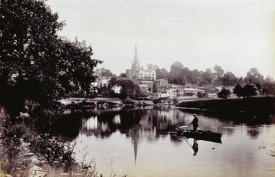 Byen Ross-On-Wye, set fra en flodbred. I forgrunden en mand, der står på en robåd af Francis Frith