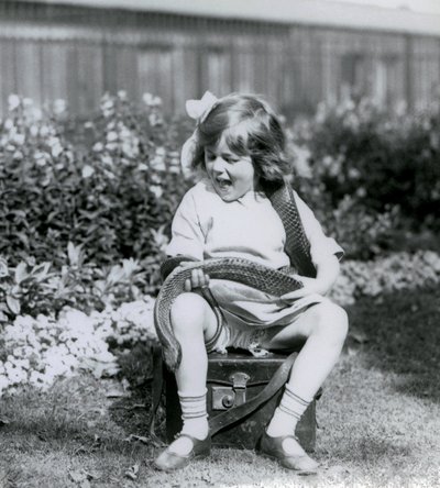 En ung pige Betty holder en østlig indigo slange, mens hun sidder på en læderstamme, London Zoo, 1924 af Frederick William Bond