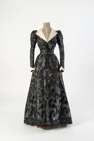 Sort silkekjole med højhalset kemisette af cremeblonde, tidlige 1890