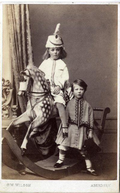 Ung pige med hat på gyngehest med en anden pige stående, 1860