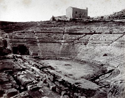 Resterne af det græske teater i Siracusa i Neàpolls monumentale park. I forgrunden det halvcirkelformede orkester og caveaen af Giorgio Sommer