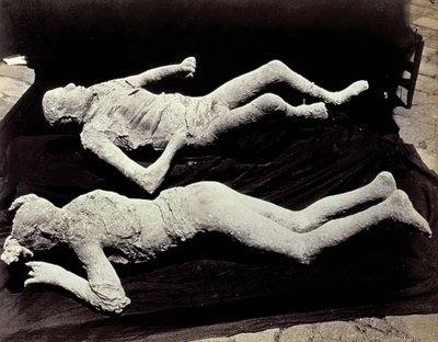 To afstøbninger af menneskefigurer fra udgravningerne i Pompeji. Udstillingerne blev placeret på sort klæde for at fotografere dem af Giorgio Sommer