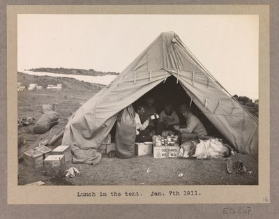 Fire ekspeditionsmedlemmer spiser frokost i et telt af Herbert Ponting