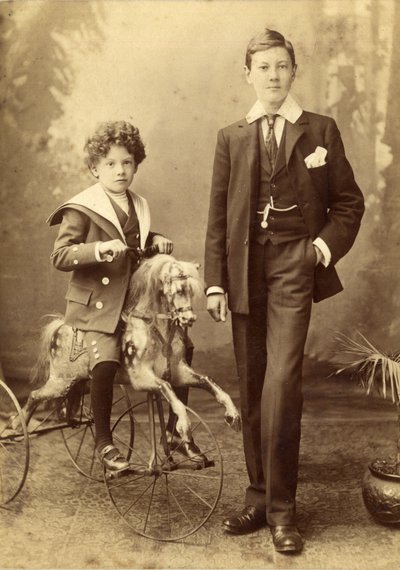 Ung dreng på sin hest monteret som en trehjulet cykel, hans ældre bror ved siden af, 1880