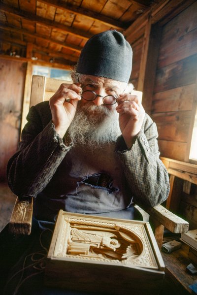 En mestersnedker og ortodoks præst poserer med sit værk. Athos-bjerget, Grækenland. af James L Stanfield