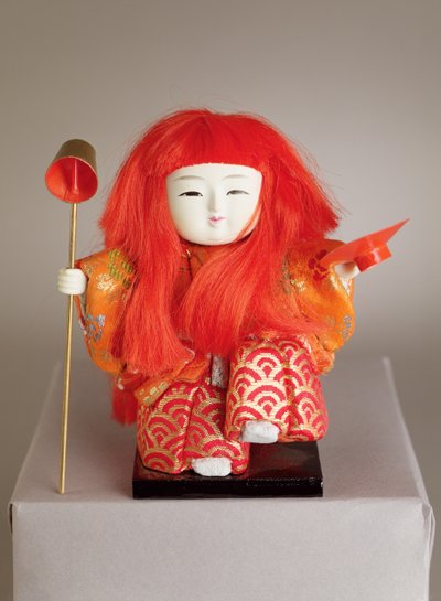 Festivaldukke af en tjener, der holder en dipper og fad af Japanese School