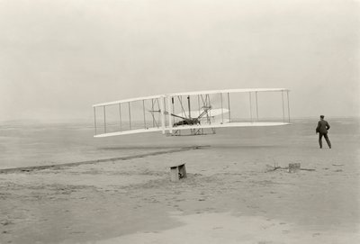 Wright Flyer I laver sin første flyvning på 120 fod på 12 sekunder i Kitty Hawk, North Carolina af John T. Daniels