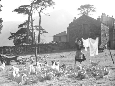 Landmandskone hænger vasketøj ud med fjerkræ i forgrunden ved Loweswater af Joseph Hardman