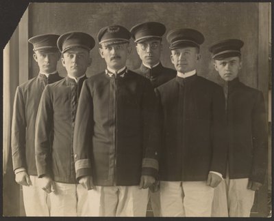 [Gruppe af unge mænd i uniform foran billedtæppe (kadetter)]. af Louis Fleckenstein