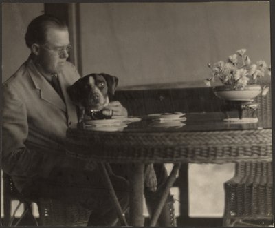 [Mand og hund sidder ved et bord]. af Louis Fleckenstein