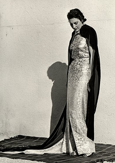 Model i aftenkjole skabt af det italienske couture-hus "Dragoni". Artiklen er suppleret med en lang fløjlskappe (s/h foto) af Luis Bogino
